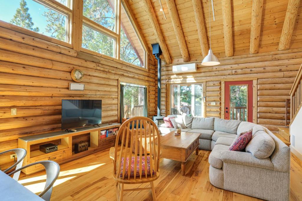 a living room with a couch and a tv in a log cabin at Walk to Pine Mountain Lake: Spacious Family Cabin in Groveland