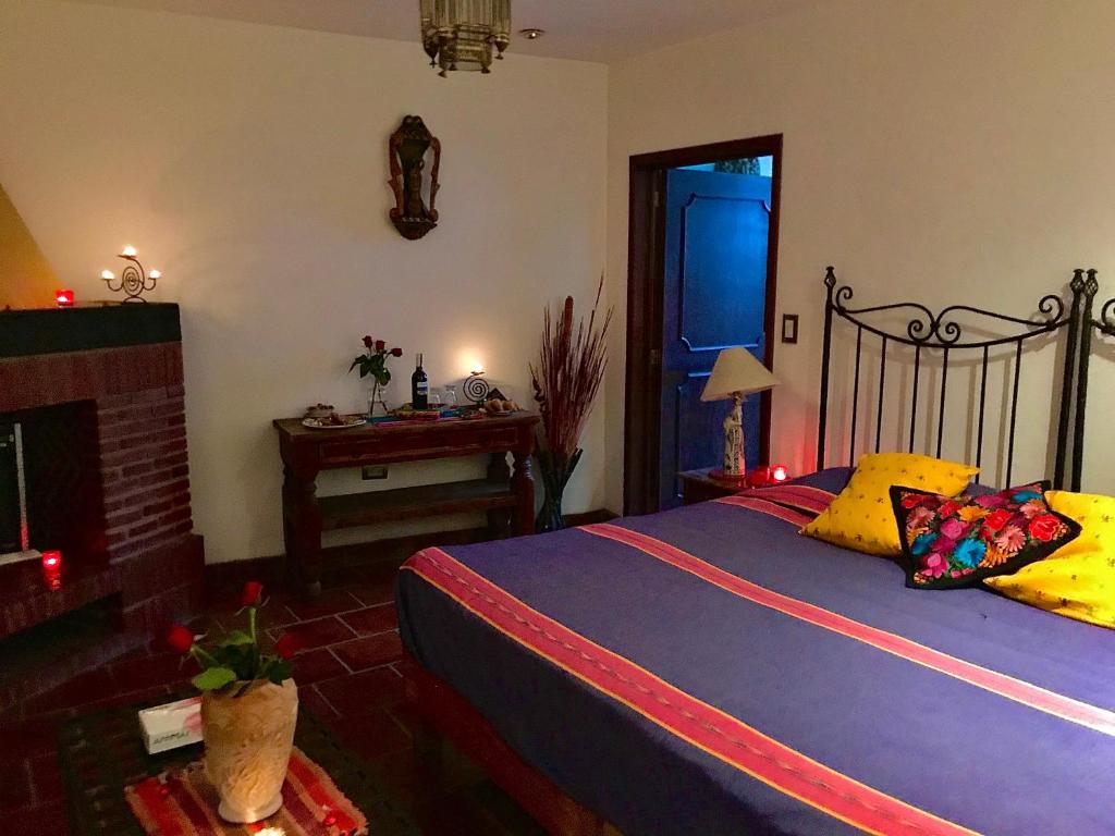 a bedroom with a bed and a fireplace and a table at Hotel Casa Santos Guanajuato in Guanajuato