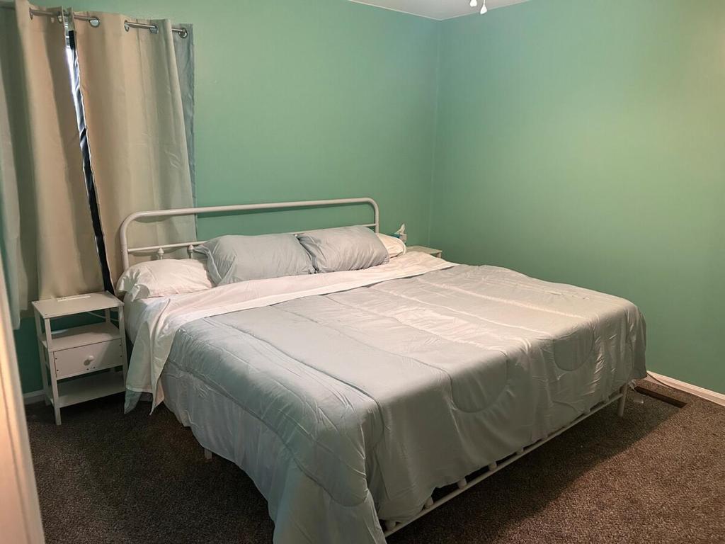 a bed in a room with a blue wall at 3 bed room lake cottage in Geneva