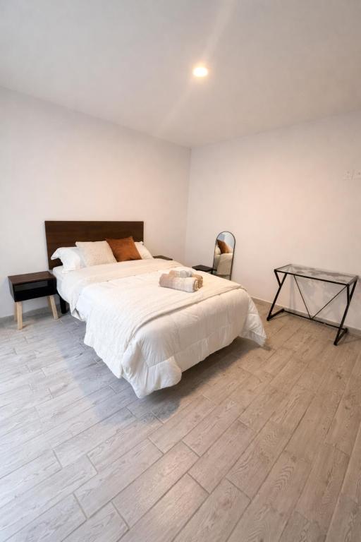 a bedroom with a large bed and a glass table at Quiet Private Room in El Pueblito