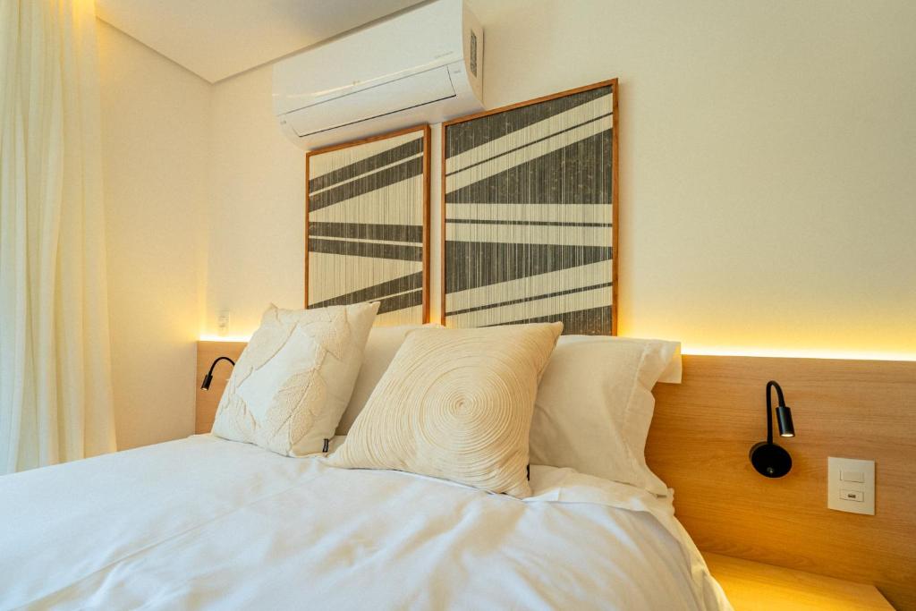 a bedroom with a bed with white sheets and a window at Loft no Granja Brasil Resort, Itaipava centro, Estrutura Completa in Araras Petropolis