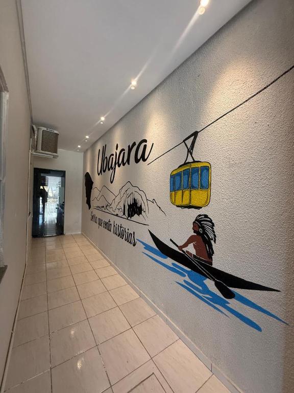 a wall with a painting of a man in a kayak at Serra Charm House in Ubajara