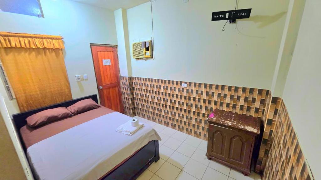 a small bedroom with a bed and a mirror at Hospedaje RIO BLANCO in Iquitos