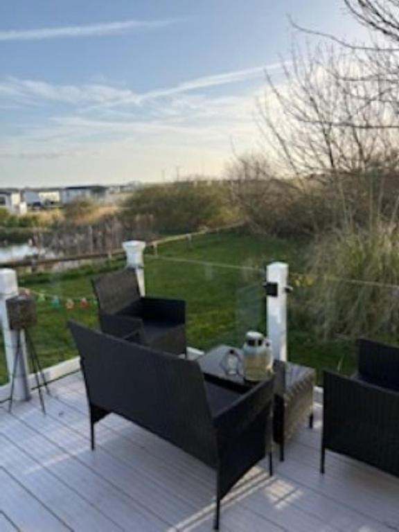a patio with two chairs and a table on a deck at Honey's Retreat in Hull