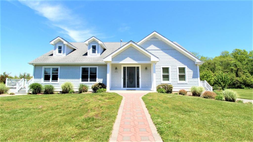 a white house with a brick driveway at Fairwinds Cottage in Cape May