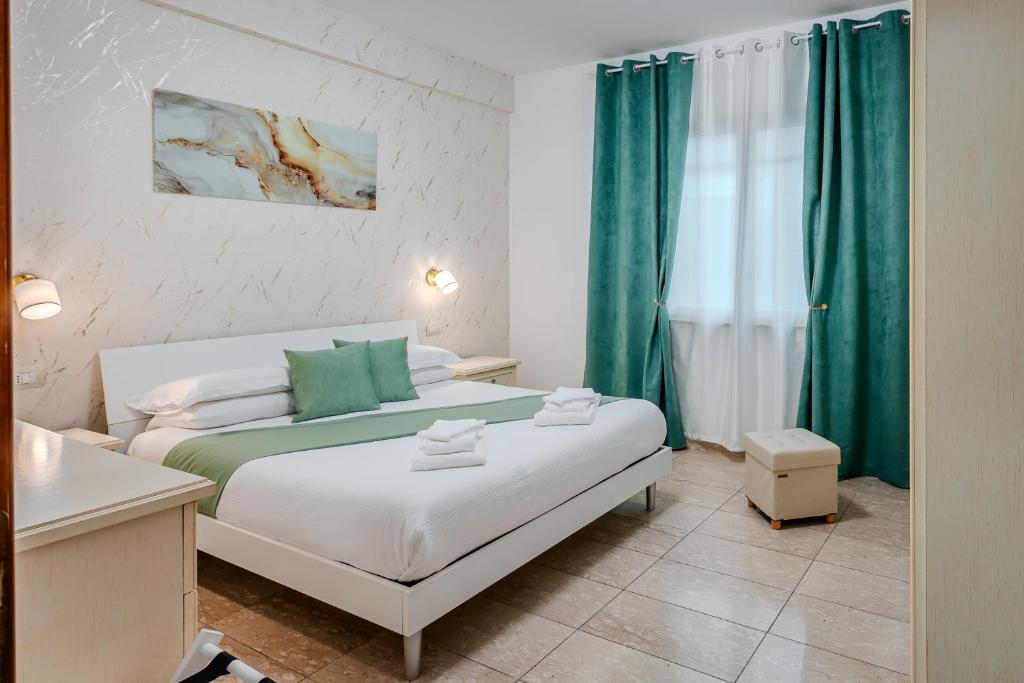 a bedroom with a large bed with green curtains at Port Haven Suite Civitavecchia in Civitavecchia
