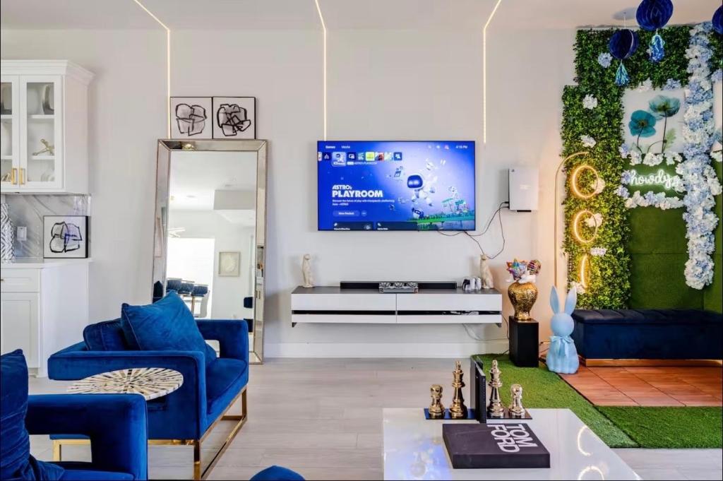 a living room with blue couches and a tv at Villa De Briley - Luxury Creator Station - Fire Pit in Houston
