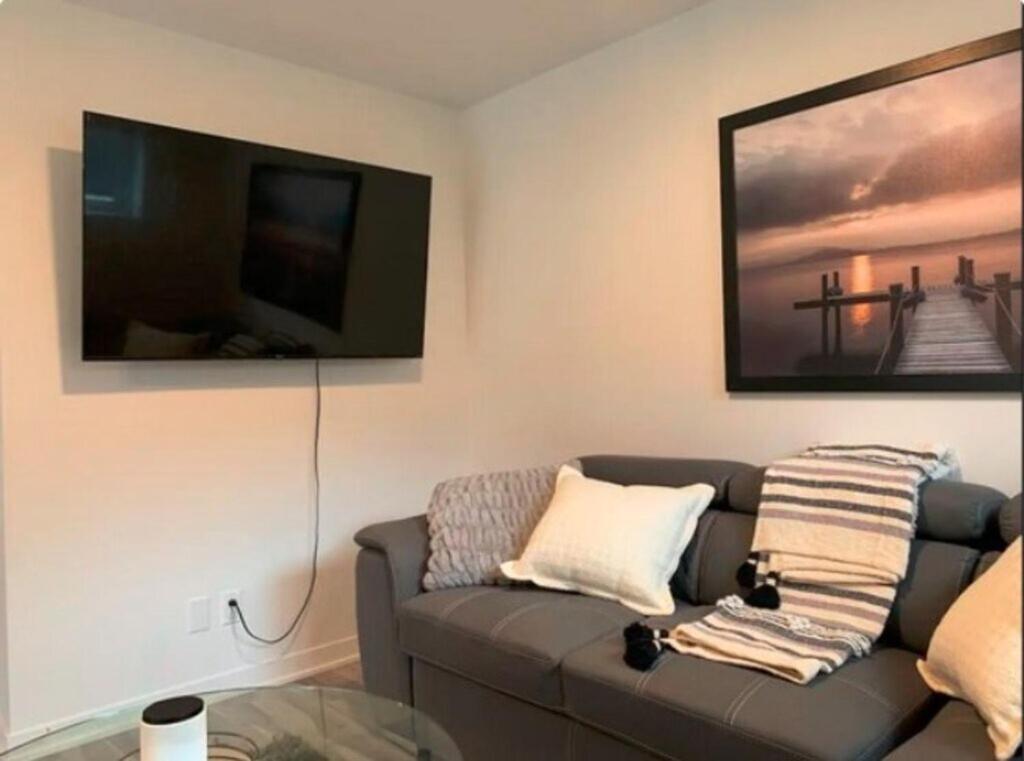 a living room with a couch and a flat screen tv at Cozy 1BR Apt perfect for Couple in Longueuil