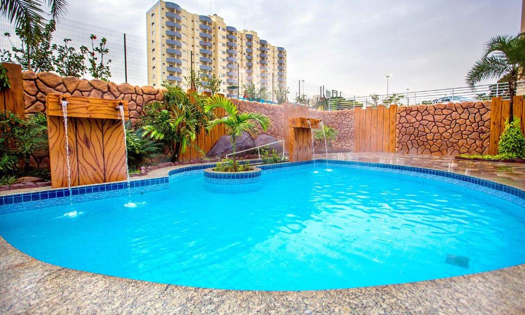 a swimming pool with a waterfall in a backyard at Flat in Caldas Novas in Caldas Novas