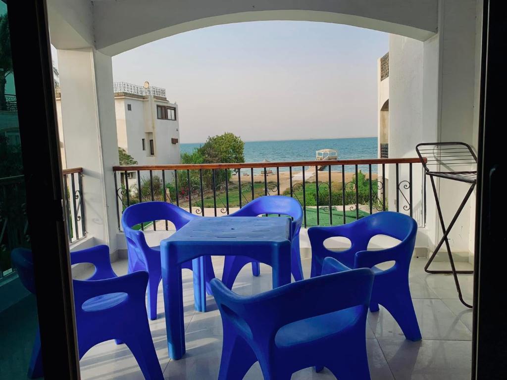 a blue table and chairs on a balcony with the ocean at قريه نڤيرت in Fayed
