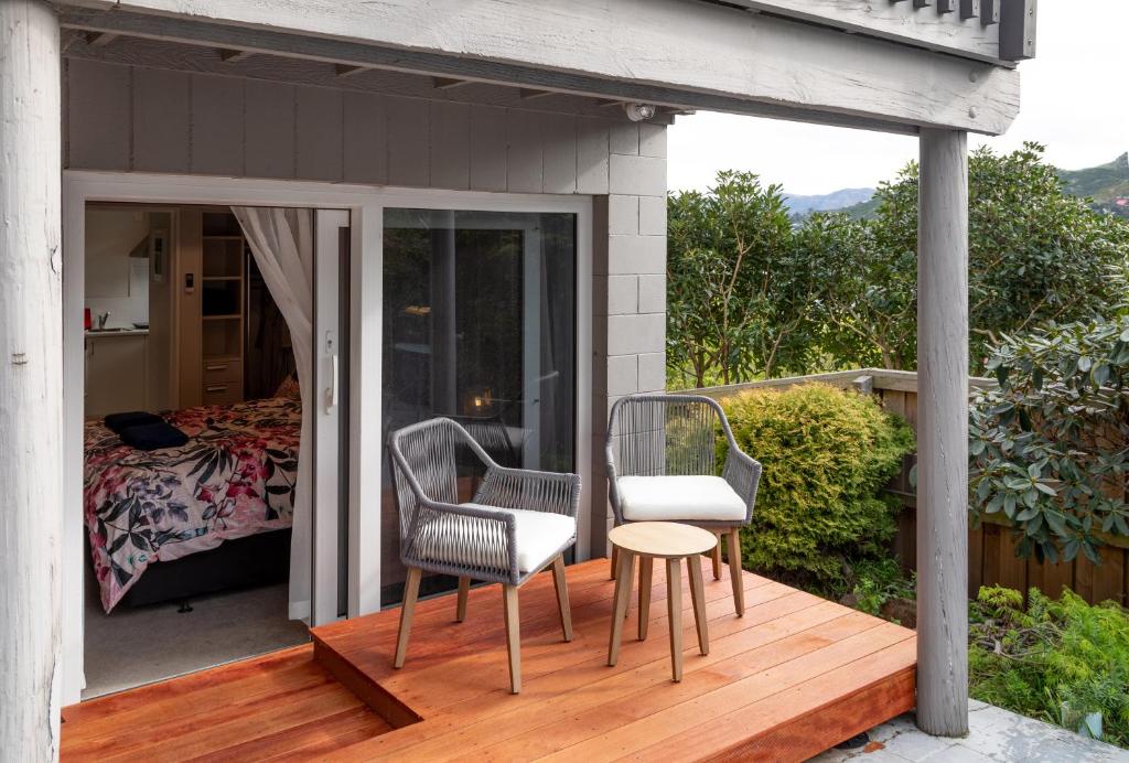 a patio with two chairs and a table on a deck at Stylish Lyttelton Studio Free Parking in  Lyttelton