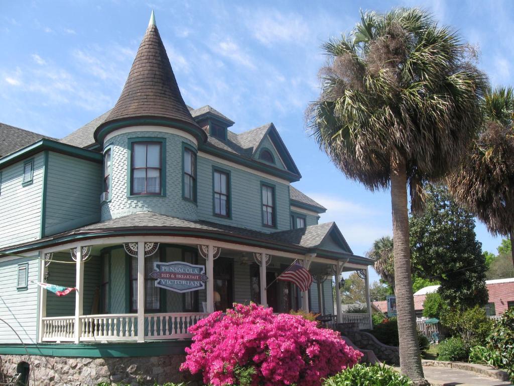 a house that has a tree in front of it at Pensacola Victorian Bed & Breakfast in Pensacola