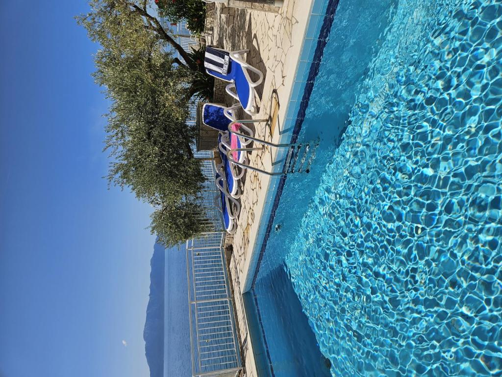 an overhead view of a swimming pool with lounge chairs next to it at Apartments and rooms with a swimming pool Brist, Makarska - 15620 in Brist