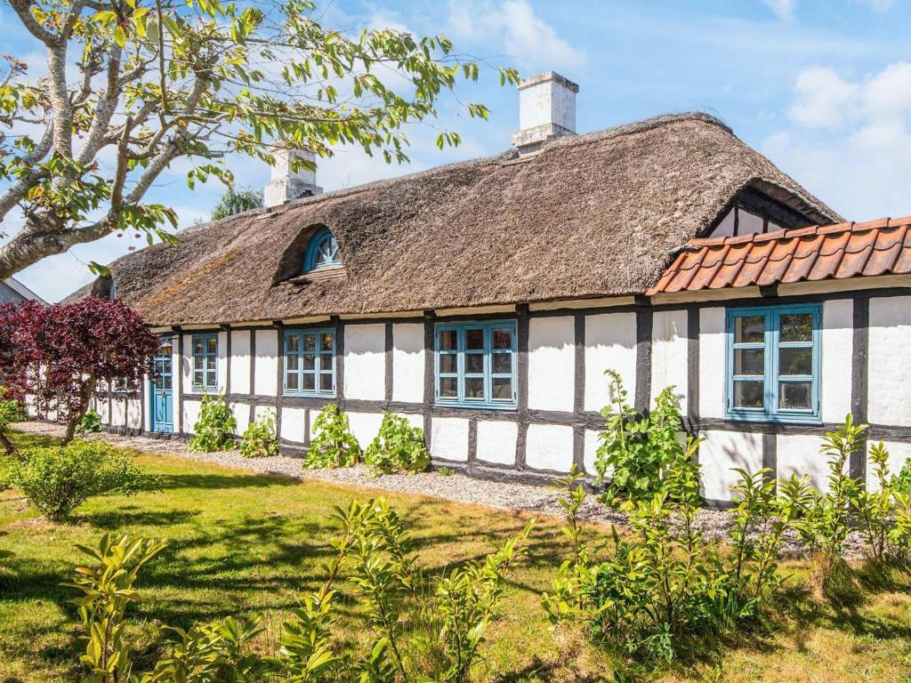 an old house with a thatched roof at House with beautiful garden in Glesborg
