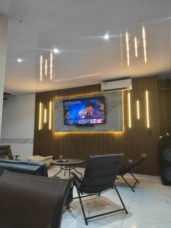 a room with chairs and a tv on a wall at RICAURTE CASA PISCINA PRIVADA in Ricaurte