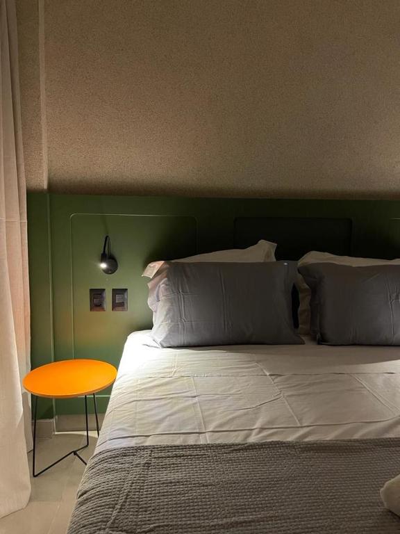 a bedroom with a bed with a green headboard and a table at Ap 101 concept BobZ in Barrinha