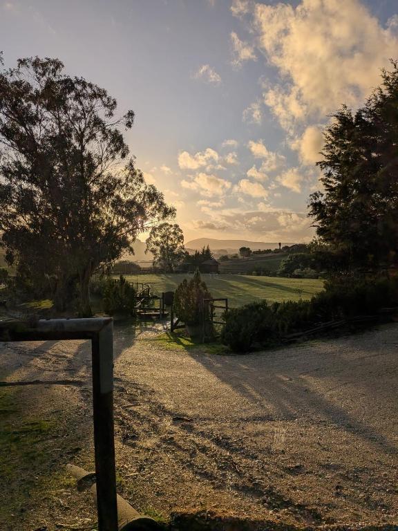 a dirt road with a fence and trees in a field at Herdade da Hera in Azambuja