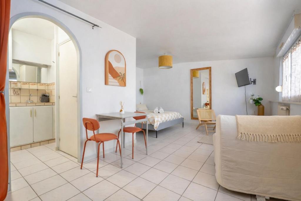a living room with a table and chairs and a bedroom at Cocon Studio proche Disneyland in Lagny