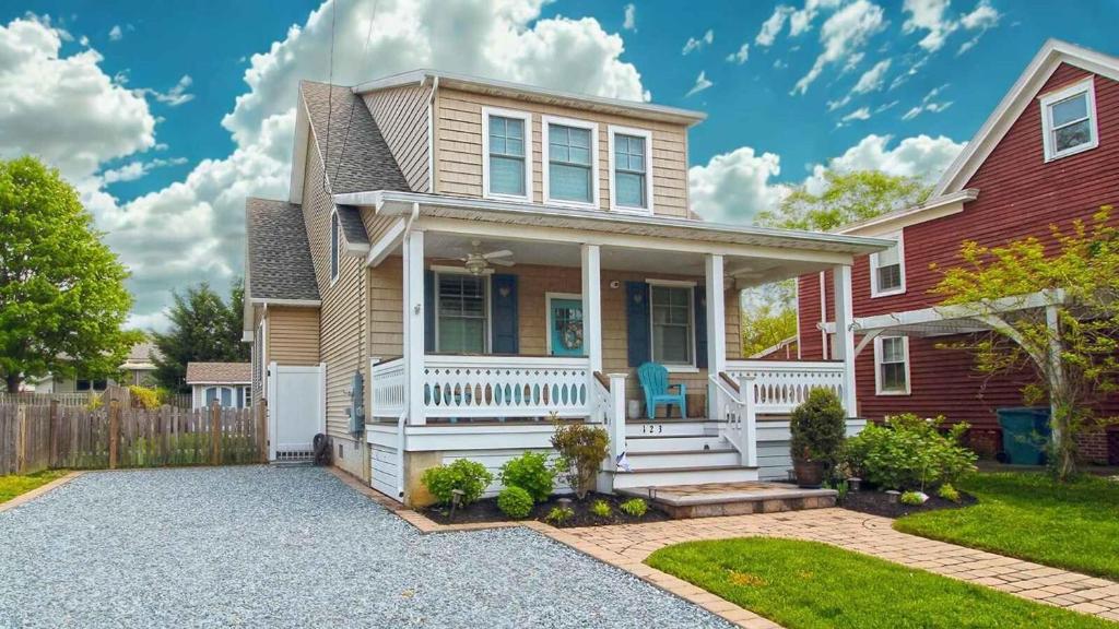 a house with a white porch and a fence at Beach Croft in West Cape May