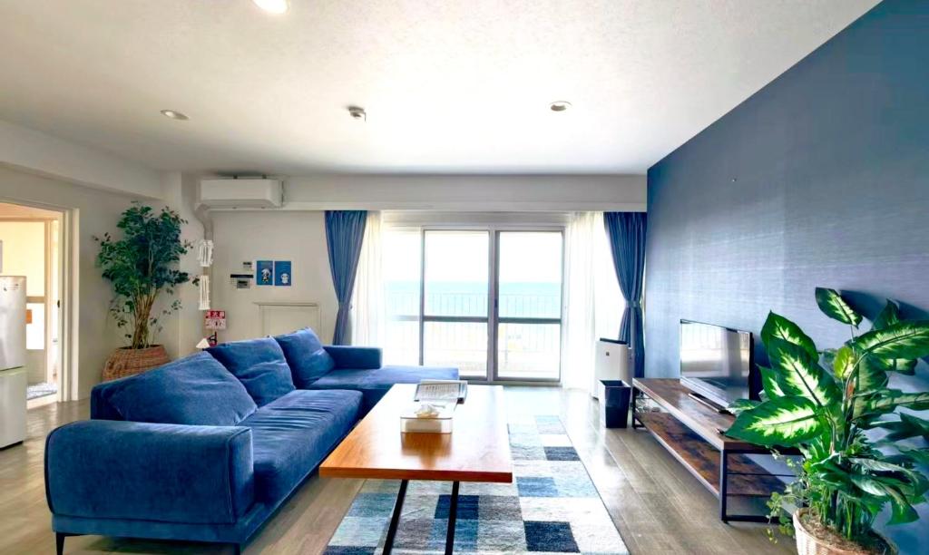 a living room with a blue couch and a table at Blu Mare in Ō-shima
