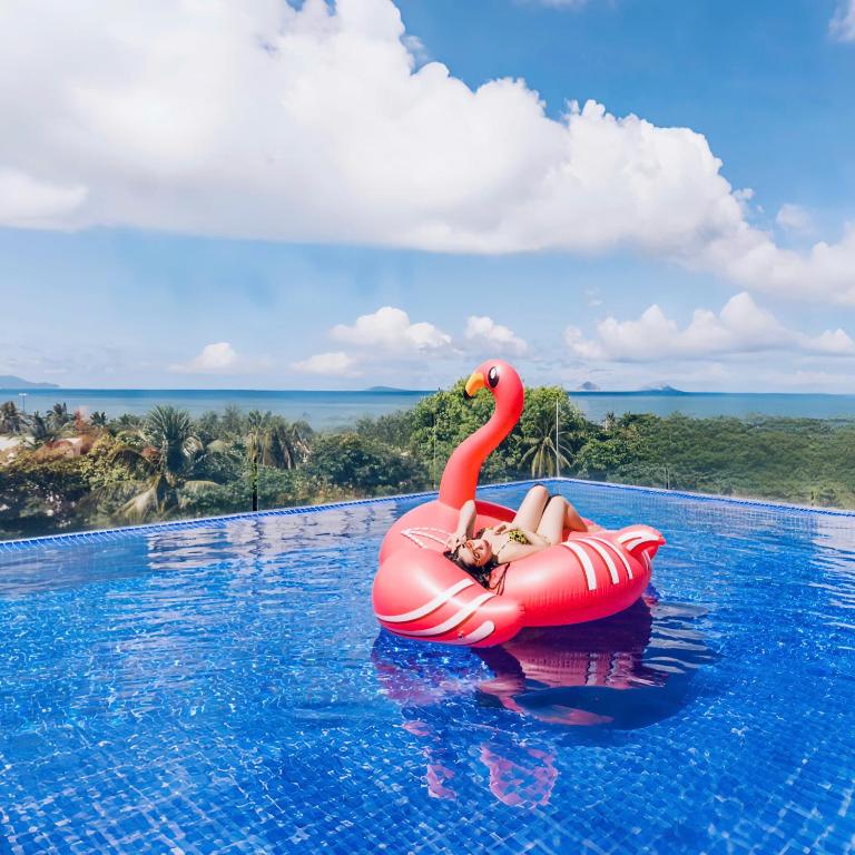 a woman on an inflatable flamingo in a swimming pool at Quinter Central Nha Trang in Nha Trang