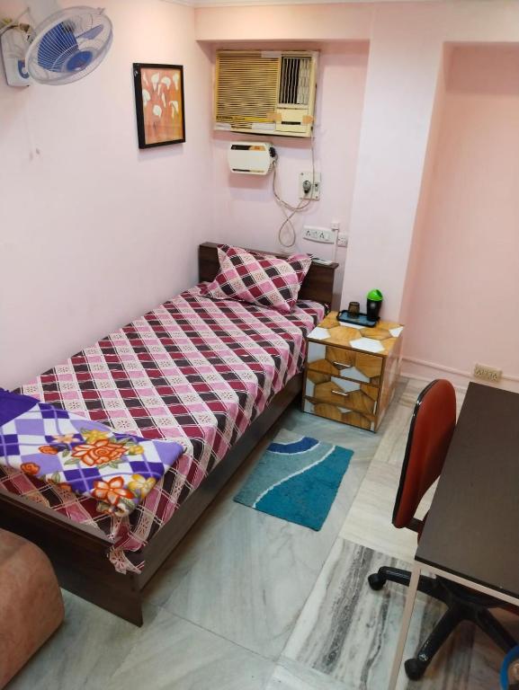 a bedroom with a bed and a table and a chair at WISHTREE CORPORATE MENS only DORMITORY FOR TECHIES AND Trainees in Chennai