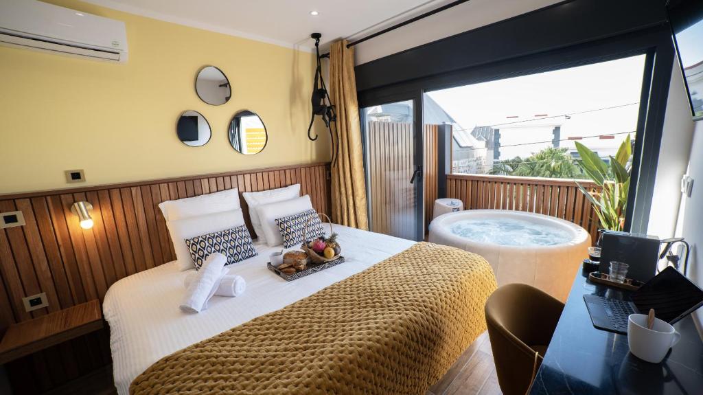 a room with a bed and a jacuzzi tub at Maison Le Patio Jacuzzi in Saint-Denis