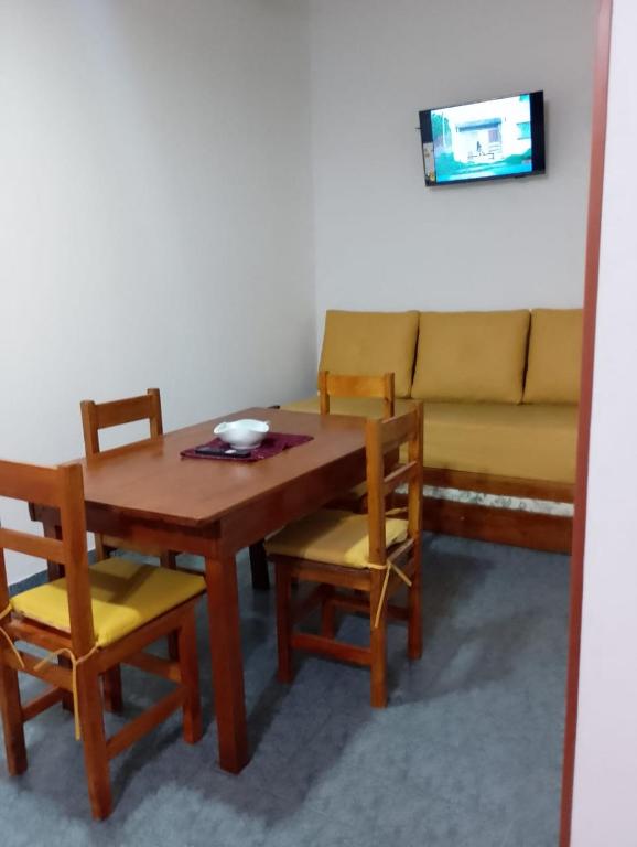 a dining room with a table and chairs and a couch at Tomás in Mar de Ajó
