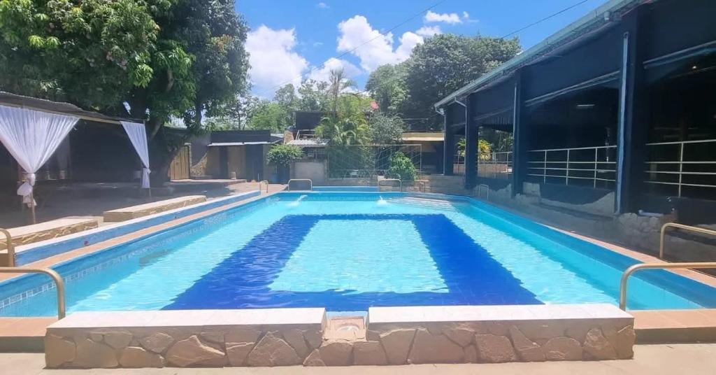 a large swimming pool with blue water in a building at Depa más pileta en Ypane in Ypane