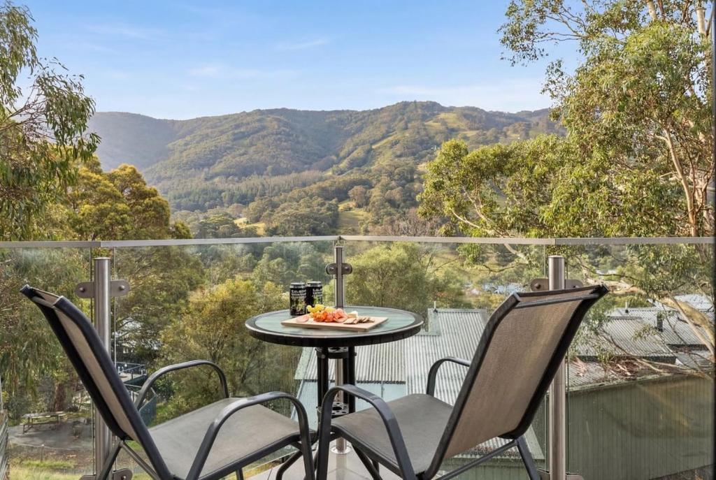 a table and chairs on a balcony with a view of mountains at Lantern 05 - Balcony in Thredbo