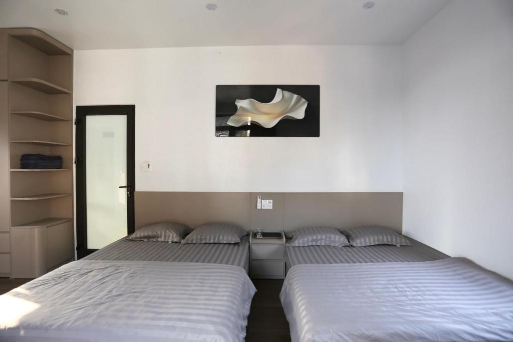 two beds sitting next to each other in a room at VITA Homestay in Cat Ba