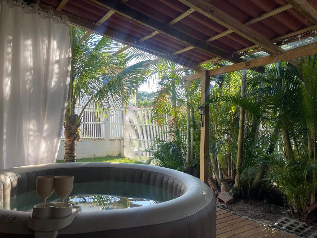 a bath tub sitting on a deck with a patio at Kit luxo com spa aquecido in Florianópolis