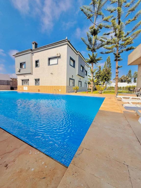 a house with a swimming pool in front of a house at Villa Safaa Dar Bouazza in Dar Mouddene