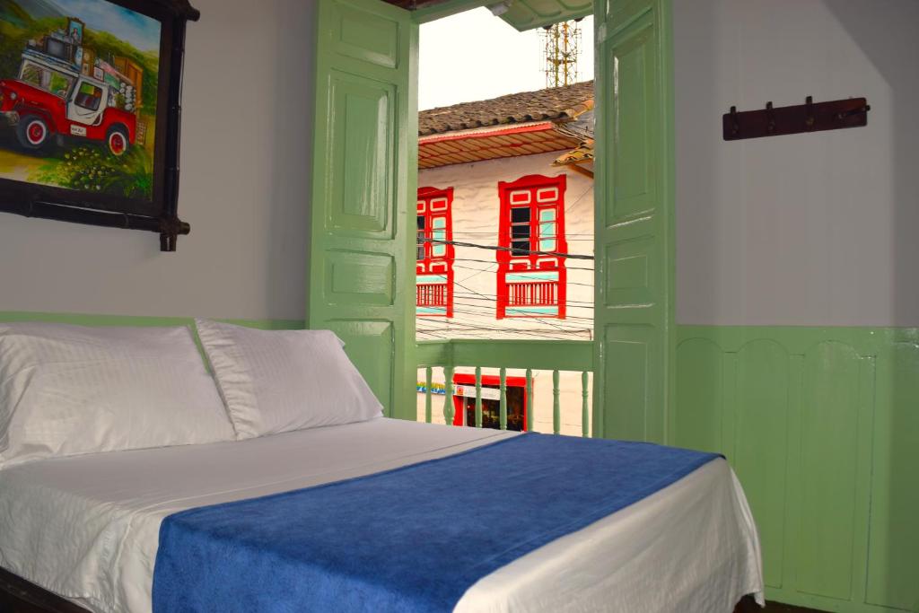 a bedroom with a bed and a window with a fire truck at FILANDIA HOTEL in Filandia