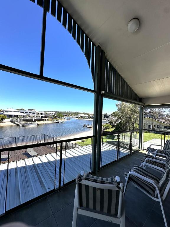 a balcony with chairs and a view of the water at Waterfront Retreat Mooloolaba in Mooloolaba