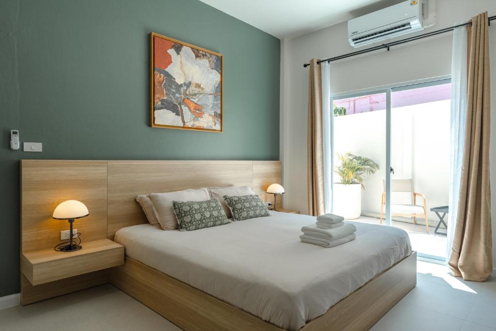 ein Schlafzimmer mit einem großen Bett und einem großen Fenster in der Unterkunft Chambers in Phuket