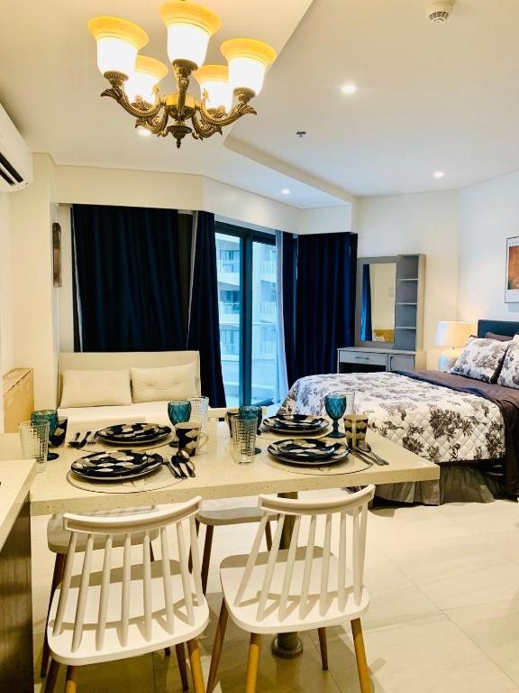 a bedroom with a bed and a table and chairs at Carolina Peach, Studio unit E-6H Tambuli Resort! in Maribago