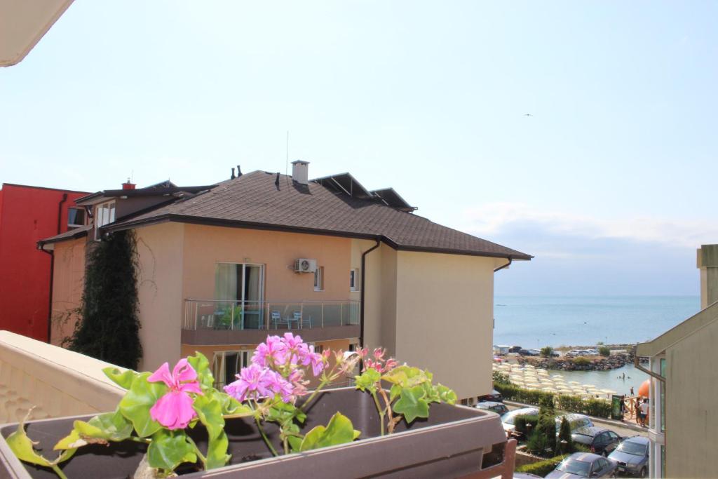 a balcony with flowers and a view of a building at Villa Amadeus in Nesebar