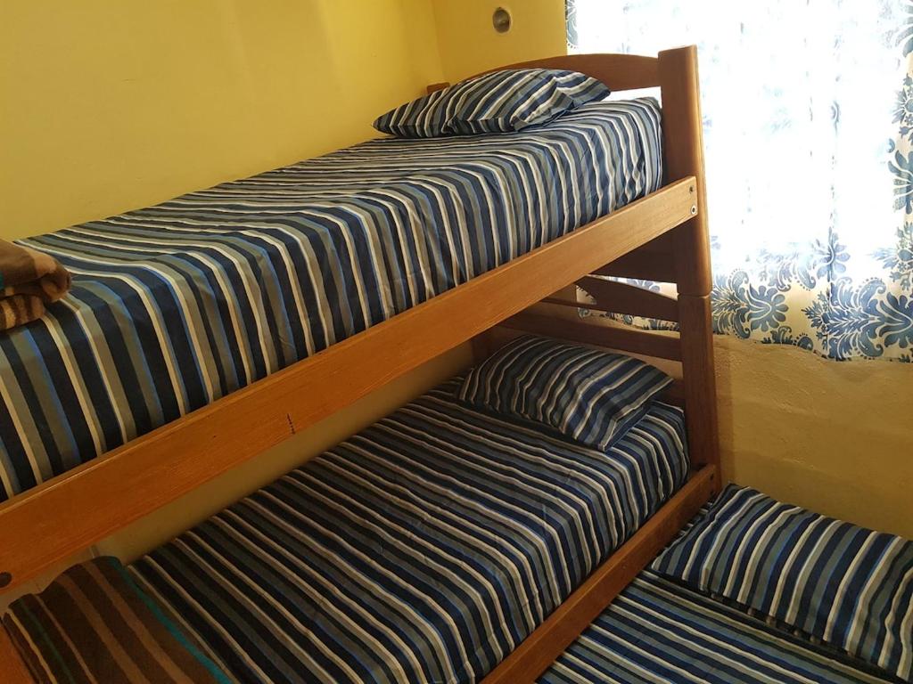 two bunk beds in a room with a window at Small room with bunk bed, bathroom, AC and WiFi in Ing. Alberto Acuña Ongay International Airport