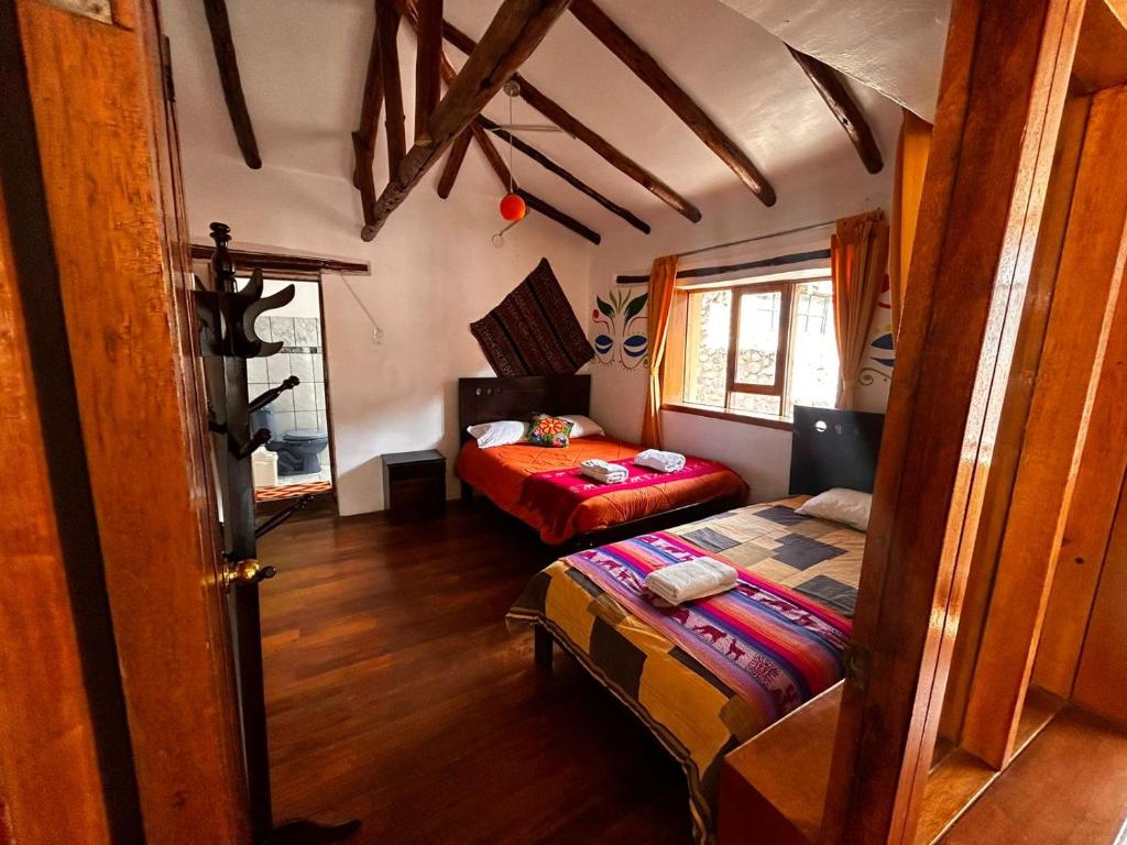 a bedroom with two beds in a room at Willka Lodge in Ollantaytambo