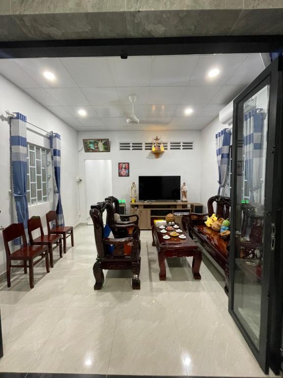 a living room with a couch and a tv at Vùng ven Homestay in Cho Lach
