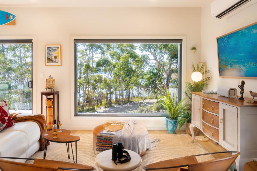 a living room with a large window and a couch at Studio 216 - Oceanview Studio with Bath, Romantic Bruny Escape in Alonnah