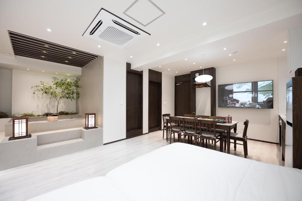 a dining room and living room with a table and chairs at ryeoan seomyeon in Busan