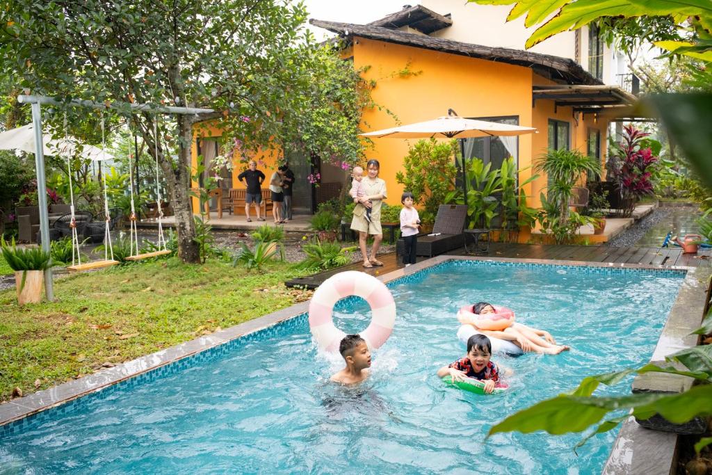 a group of people in a swimming pool with a swimming circle in the water at KuTÓN ECOCAMP in Lương Sơn