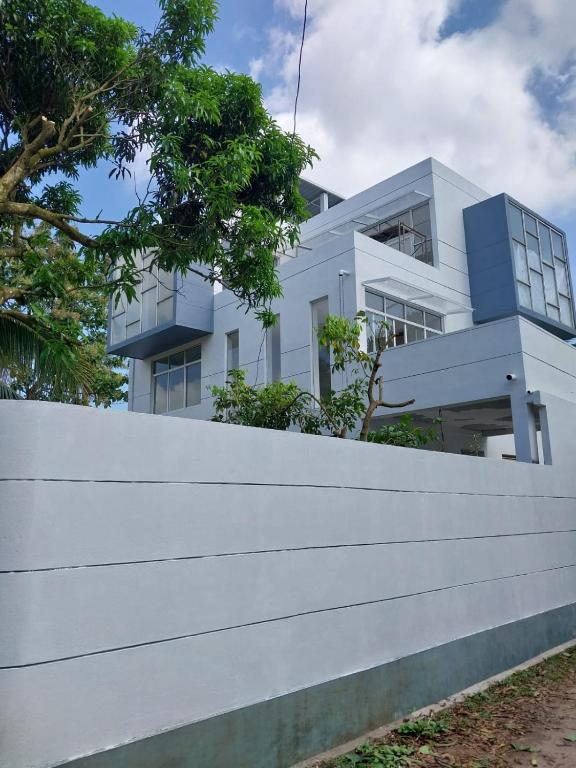 a white building behind a white fence at The white house in Kelaniya