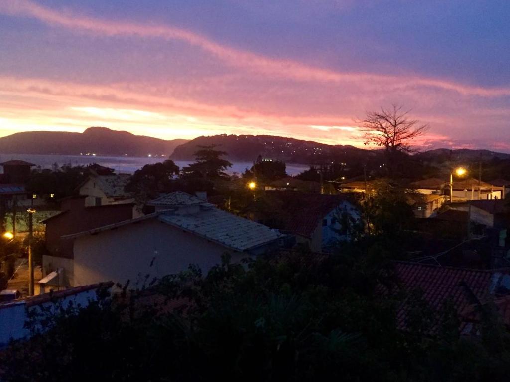 una vista de la ciudad por la noche con una puesta de sol en Aldeia de Geribá - Jardim, piscina e praia, en Búzios