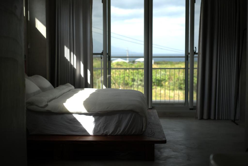 a bedroom with a bed and a large window at Tomoya in Chenggong
