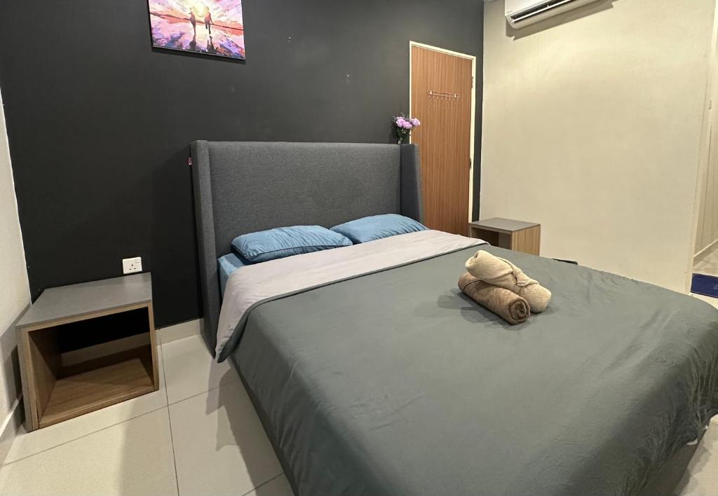 a bedroom with a large bed with blue pillows at Cozy Stays Studio - Kozi Square Kuching in Kuching