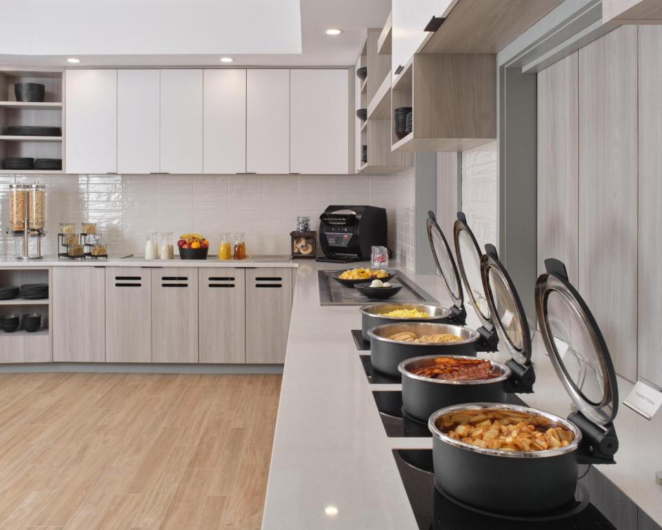 a kitchen with several bowls of food on a counter at Hyatt House Schenectady / Mohawk Harbor in Schenectady