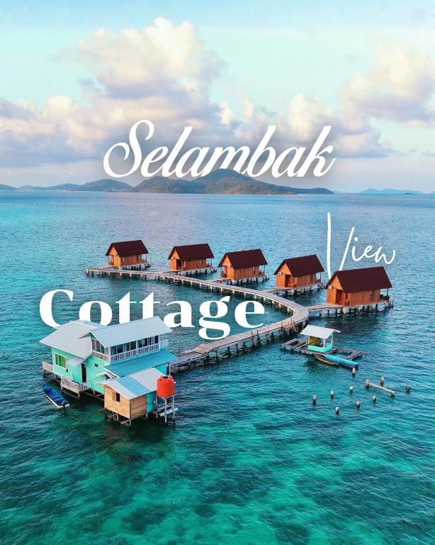 a group of houses on a dock in the water at Selambak View Cottage in Pulau Siantan